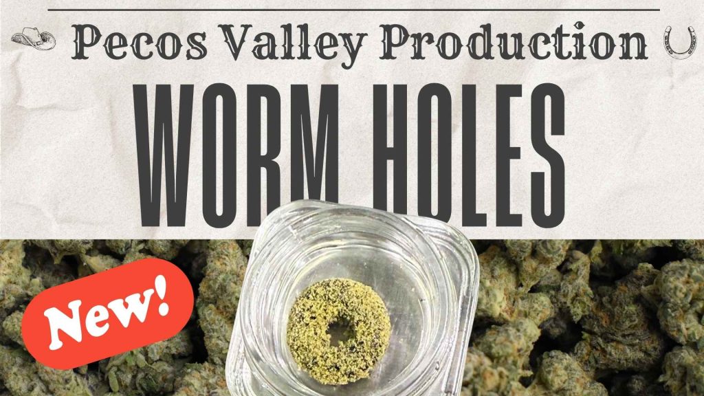 A promotional image for Pecos Valley Production's new Worm Holes cannabis extract product, featuring a textured beige background with a large black-and-white logo of a steer skull at the top and the brand name in elegant Western-style lettering. The title "WORM HOLES" appears prominently in bold black uppercase letters below, with a red "New!" badge in the upper right corner. In the center, a clear glass jar holds a yellowish, doughnut-shaped concentrate piece sprinkled with green cannabis flower bits, surrounded by scattered green nugs on a neutral surface at the bottom.